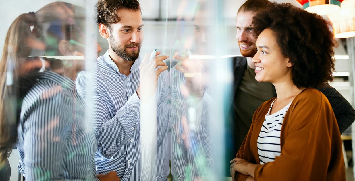 Team collaborating on a glass board